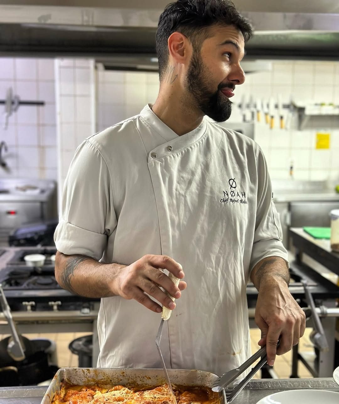 Chef servindo lasanha gratinada na cozinha