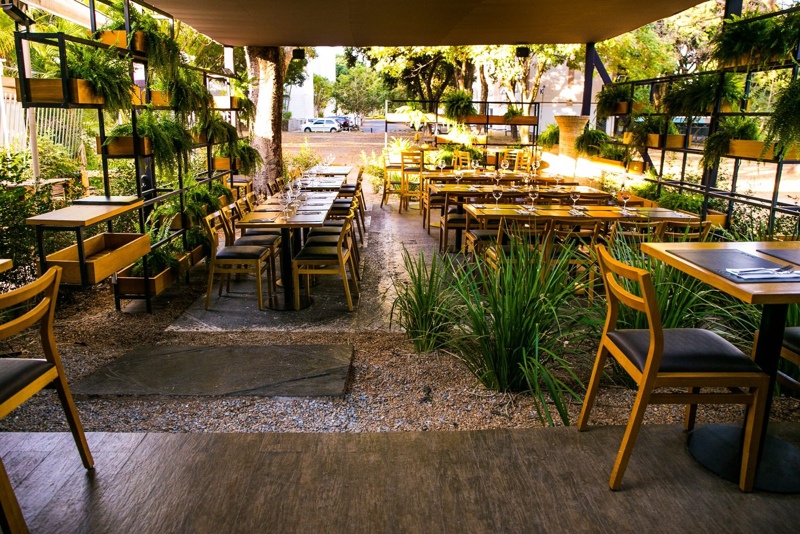 Jardim do NOAH com mesas postas sob a pérgola