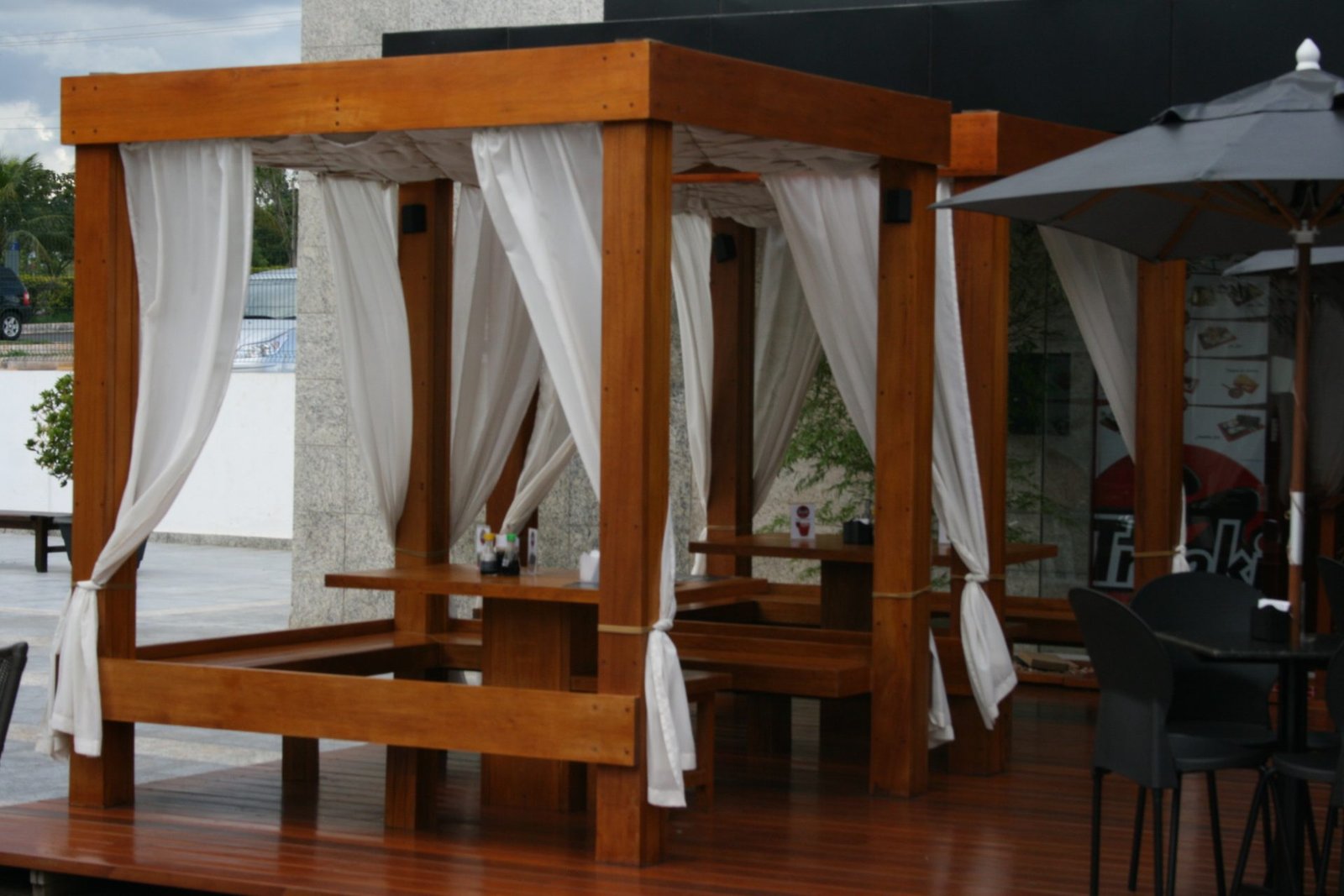 Cabanas de madeira com cortinas brancas no deck